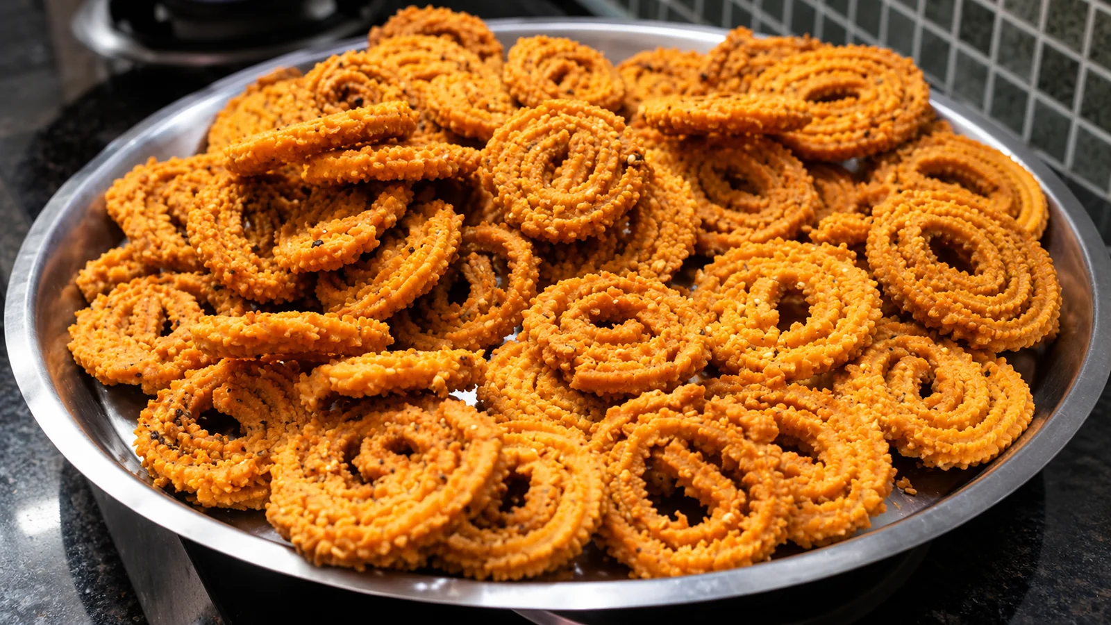 A platter piled with golden South Indian murukku spirals, showing their ridged texture.